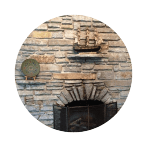 Stone fireplace with ship and rosemaled plate